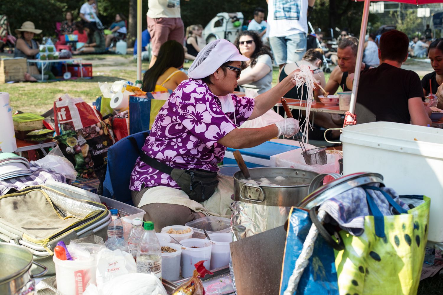הגברת שמכינה מרק אטריות ונתחי חזיר בשוק התאילנדי